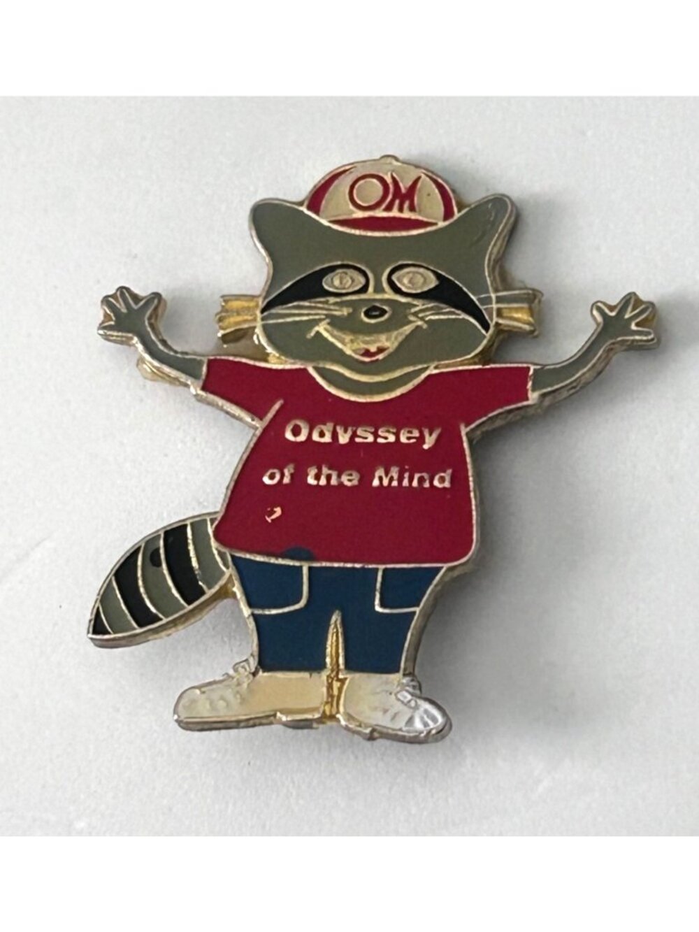 Odyssey of the Mind Omer Mascot Lapel Pin wearing an Odyssey T shirt